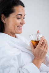 pretty woman in a bathrobe enjoying a cup of tea