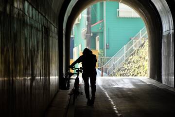 小坪トンネルを自転車を押して歩く人