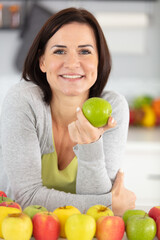 smiling woman holding green apple
