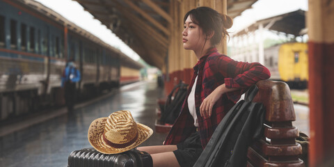 Young traveler woman looking for friend planning trip at train station. Summer and travel lifestyle...