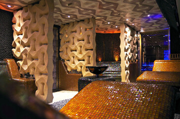 Turkish bath or steam sauna with mosaic tiles inside male locker room of spa or wellness are...