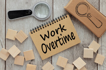 Work Overtime text on a craft notepad. business concept