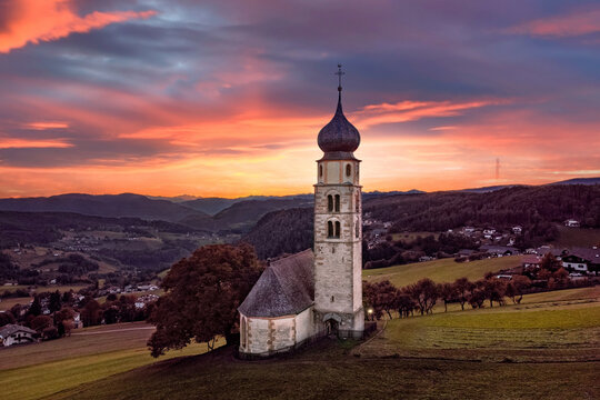 Seis am Schlern, Italy - Aerial view of the beautiful St. Valentin Church (Kastelruth) at sunset in the Italian Dolomites with and colorful clouds and warm sunlight at South Tyrol