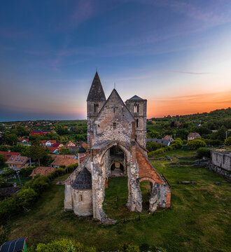 Zsambek, Hungary - Aerial view of the beautiful Premontre Monastery ruin church of Zsambek (Schambeck) with cemetery and colorful dramatic sunset at background at summertime