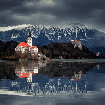 Lake Bled, Slovenia - Beautiful view of Lake Bled (Blejsko Jezero) with reflecting Pilgrimage Church of the Assumption of Maria on Bled Island, Bled Castle and Julian Alps at background at winter time