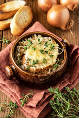 Bowl with French onion soup on wooden table