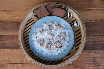 Chinese New Year festive snacks. Coconut Rolled Steamed Nian Gao Balls. Also called New Year Cake, steamed till melted then use a fork and spoon to scrap a piece and rolled with fresh graded coconut.