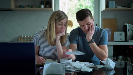 Man and woman checking payment bills in the kitchen at home. Planning family budget. Couple calculate bills and have stress