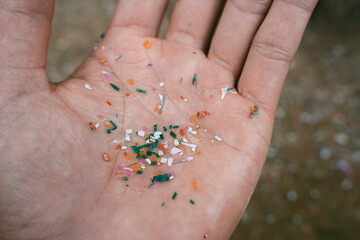 Close up side shot of microplastics lay on people hand. Concept of water pollution and global...