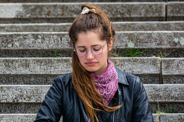 woman in leather jacket on stone stairs