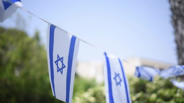 Israel flags white and blue with star Magen David fluttering in wind. many flags prepare to Independence Day of Israel. outdoor. big holiday