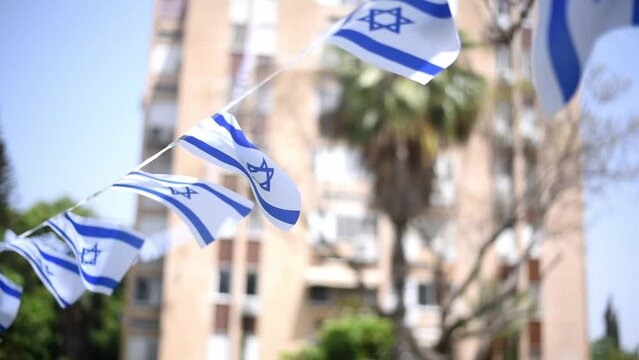 Israel flags white and blue with star Magen David fluttering in wind. many flags prepare to Independence Day of Israel. outdoor. big holiday
