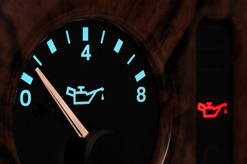 oil pressure gauge in car dashboard in illuminated night mode - low