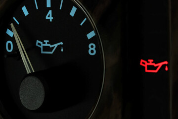 oil pressure gauge in car dashboard in illuminated night mode - low