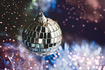 Closeup of Christmas disco ball on blurred, sparkling and fairy light background. Happy Holidays. Happy New Year and Xmas greeting card. Copyspace, selective focus. Party time.