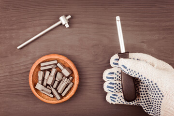 Bits and metal heads for keys on the table. Tool in hand on a dark background.