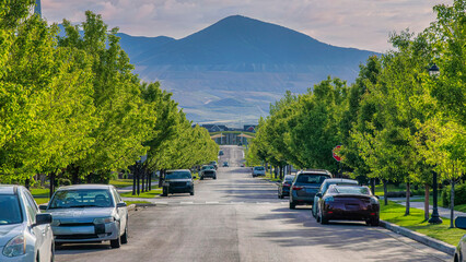 Panorama Puffy clouds at sunset Concrete road with vehicles parked on the roadside near the colu