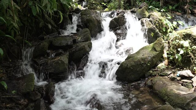 Close-up shot of a waterfall cascading down a rock in slow motion, laterite palace