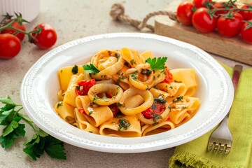 Italian pasta with calamari and tomato sauce. Calamarata is a kind of thick ring pasta paccheri,...