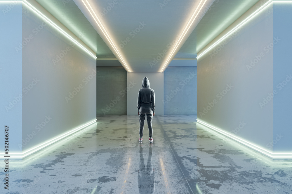 Poster Back view of hacker in hoodie in futuristic space corridor interior with white lights. Technology and architecture concept.