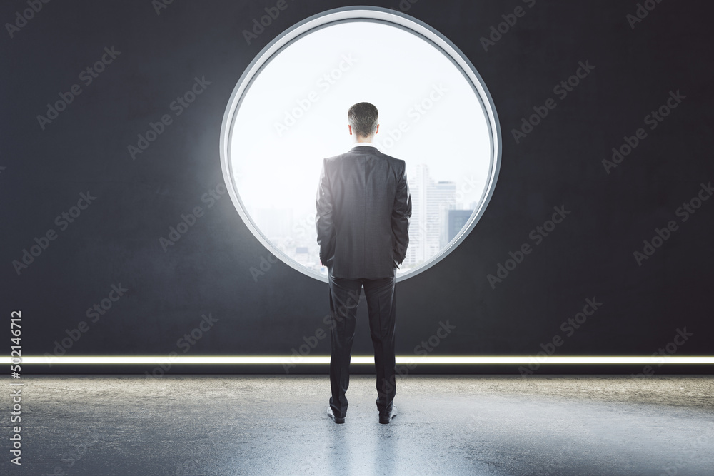 Poster back view of thoughtful young business man standing in creative modern concrete interior with round 