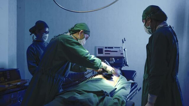 Defibrillation cardiac dysrhythmia, Surgical doctor team performing surgery patient on operating room in hospital, doctors use medical devices automated External Defibrillator to pump hearts patients