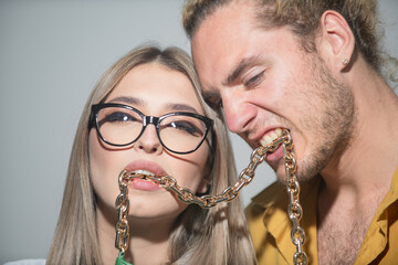 Couple with chains in mouth closeup. Youth, love and lifestyle concept. Couple of sexy man and...