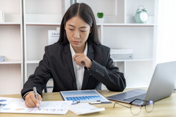 Business woman analyzing data graph in private office room, Presents Graph data and plan marketing strategies for executives who attend team meetings to analyze and develop for business.