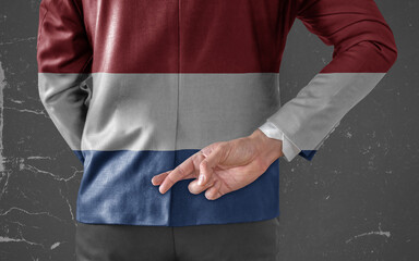 Businessman Jacket with Flag of Netherland with his fingers crossed behind his back