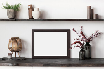 Blank picture frame mockup on white wall. Artwork in interior design. View of modern rustic scandinavian style interior with canvas for painting or poster on wall. Minimalism concept