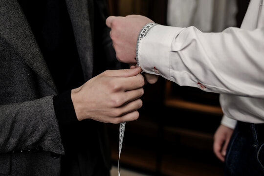  tailors taking client's measurements