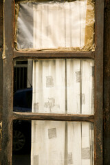 Window of old house with white curtain