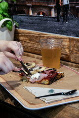 eating a slice of mushroom pizza with a beer