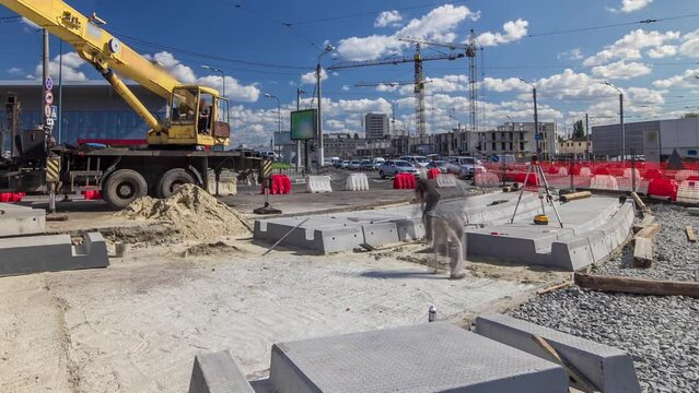 Installing concrete plates by crane at road construction site timelapse.
