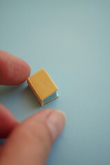 Miniature book and female fingers, mini book notepad craft on th