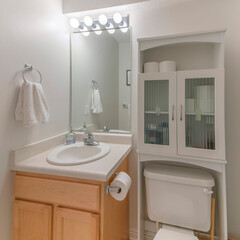 Square White bathroom interior with over-the-toilet storage cabinet