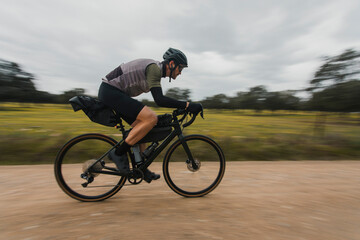 Blurred motion of cyclist cycling on dirt road
