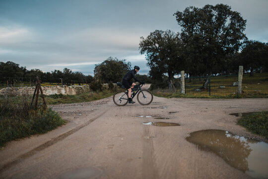 Mature man riding bicycle on gravel road