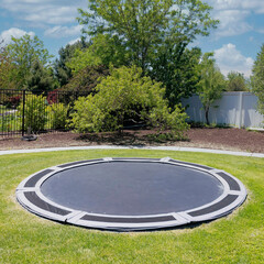 Square White puffy clouds In-ground trampoline on a lawn at the backyard in Utah