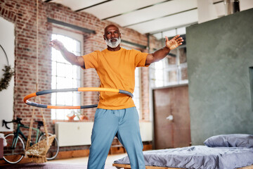 Bald man hula hooping at home
