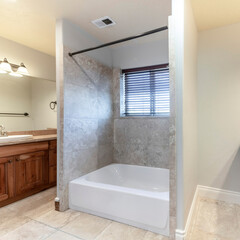 Fototapeta na wymiar Square Master bathroom with bathtub in the middle of two vanities