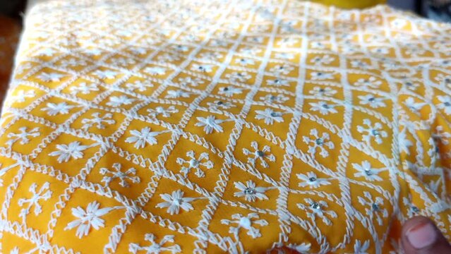 Macro shot of artisans, hand crafting mirror work on fabrics.