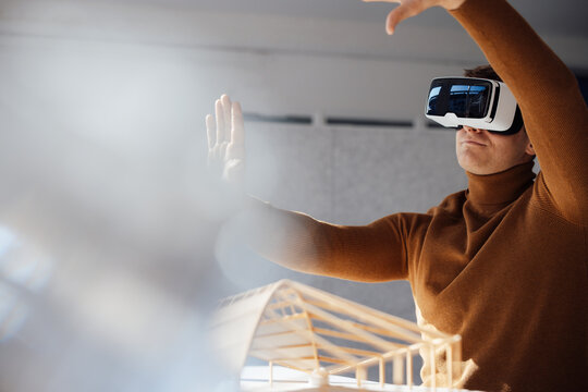 Businessman wearing virtual reality simulator gesturing in office