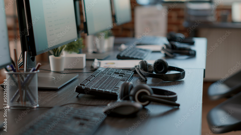 Poster empty call center office with computers and audio headsets used to have conversation with people on 