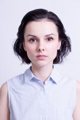Fototapeta premium woman in a blue sleeveless office shirt, light background