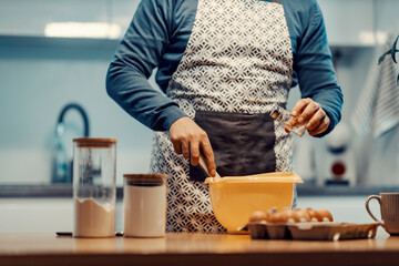 Unknown man making cake and cookies at home in kitchen.