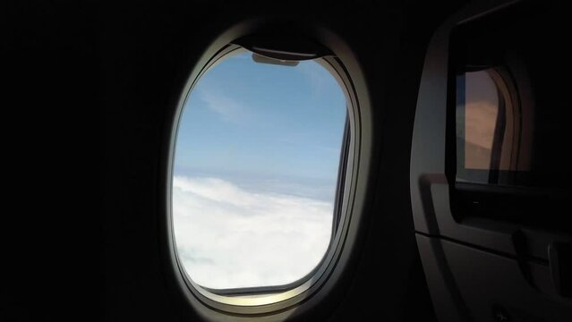 passenger window air flight with sea of clouds and blue clear sky, travel concept