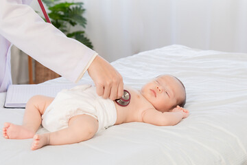 Obraz na płótnie Canvas Asian newborn baby get sick sleep during examine by pediatrician doctor hand hold stethoscope, Little child in medicine hospital. Physician hand using stethoscope examining adorable infant heart.