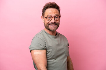 Middle age man wearing a band aids isolated on pink background with happy expression