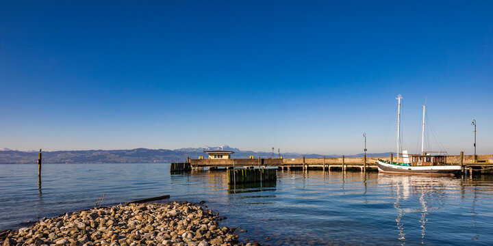 Fototapeta Germany, Baden-Wurttemberg, Langenargen, Clear blue sky over pier on shore of Lake Constance